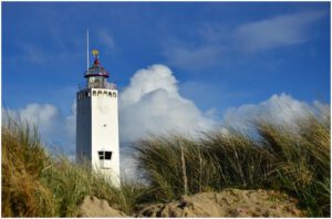 Exploring the iconic lighthouse in Noordwijk: A beacon of history and spectacular views. The towering structure stands against a backdrop of blue skies and crashing waves, its distinctive red and white stripes a symbol of maritime heritage. Visitors climb the spiral staircase to reach the top, where panoramic views of the coastline await. This captivating scene captures the allure of the Noordwijk lighthouse, inviting adventurers to discover its rich history and take in the breathtaking vistas of the North Sea.